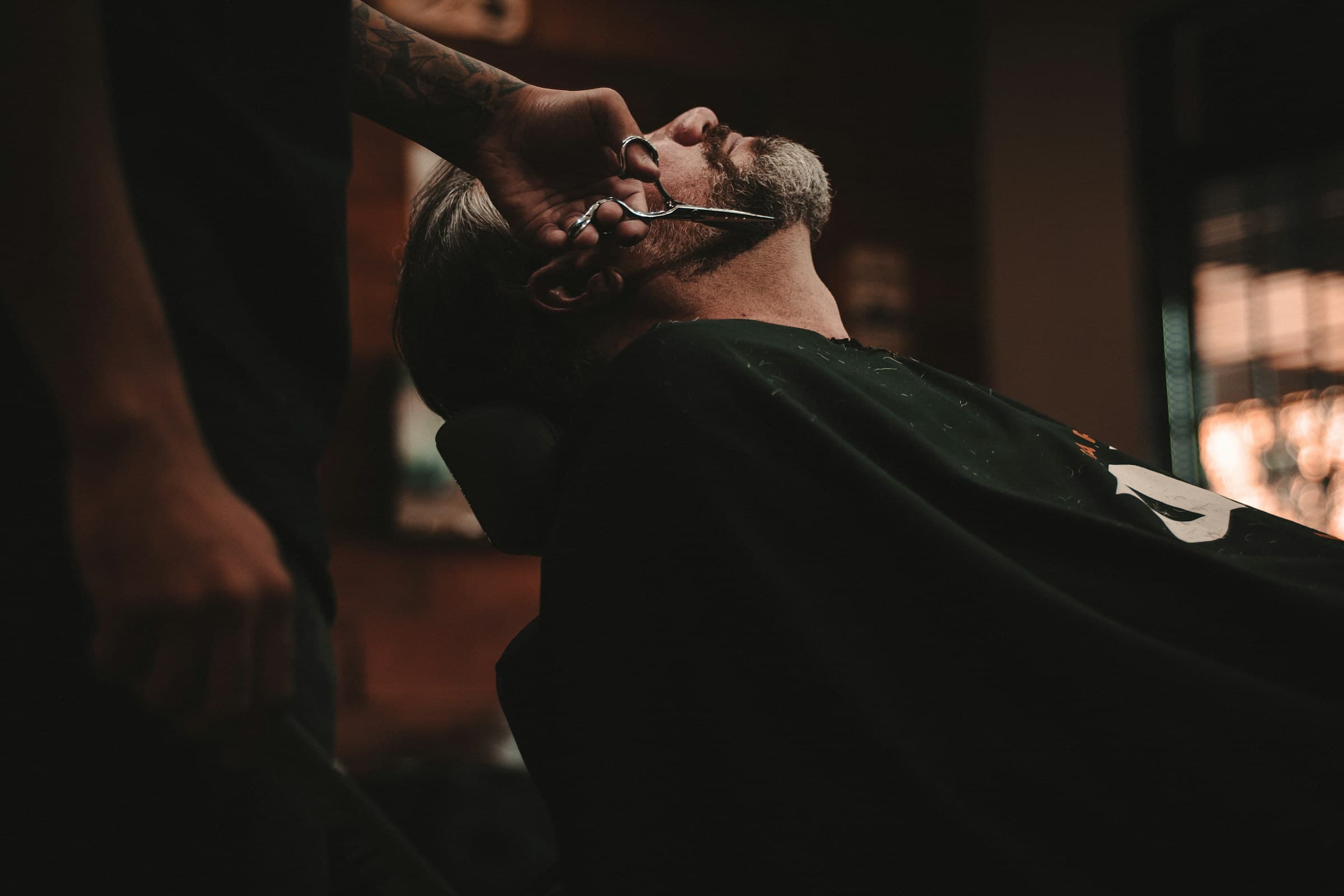 Cliente sendo atendido na cadeira da barbearia